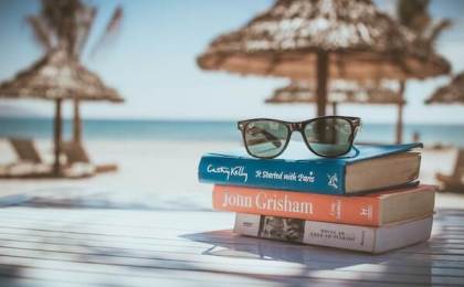 Books stacked on beach representing knowledge about insulin resistance and hormonal imbalance in women