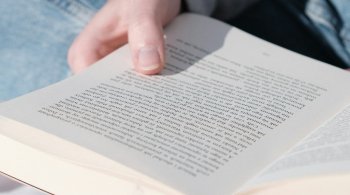 Person reading a book in soft sunlight, symbolizing calm and brain clarity