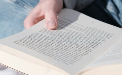 Person reading a book in soft sunlight, symbolizing calm and brain clarity
