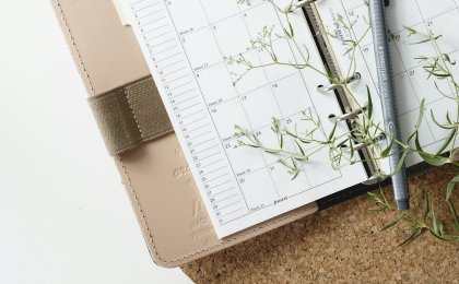 Planner with pen and flowers symbolizing mindful scheduling for self-care