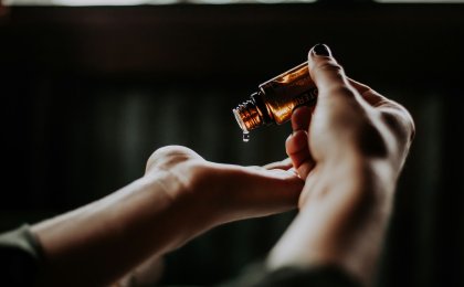 Person applying essential oil to palm as a natural remedy for skin inflammation and irritation
