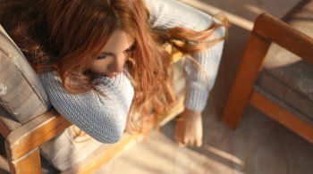 Woman resting her head on a chair, overwhelmed and exhausted from stage 2 adrenal fatigue