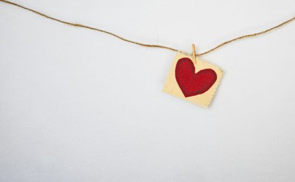 Red paper heart hanging on twine, symbolizing emotional and physical whole heart health