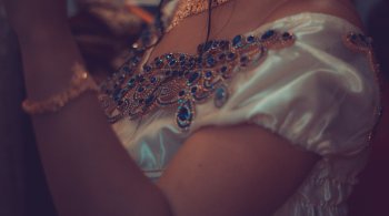 Close-up of a woman wearing a jeweled gown and necklace—symbolizing feminine strength and breast cancer awareness