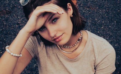 Young woman looking confident and calm while shielding her eyes from the sun