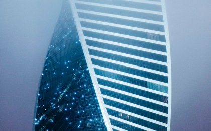 Modern spiraling skyscraper in fog, symbolizing genetic complexity and unseen pathways