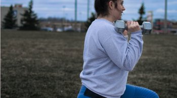 Woman performing lunges with dumbbells outdoors to improve insulin sensitivity
