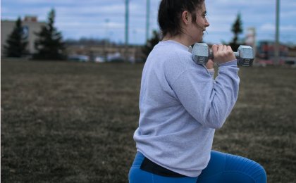 Woman performing lunges with dumbbells outdoors to improve insulin sensitivity