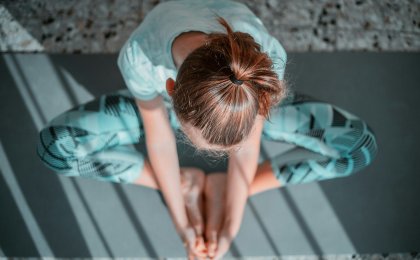 Woman in butterfly pose practicing yoga for heart and hormonal health