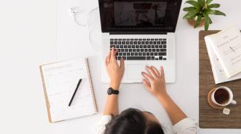 Woman researching hormonal and metabolic health at her computer with a notepad