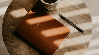 Open journal with pen and coffee cup, symbolizing mindful reflection and a gentle January detox for women.